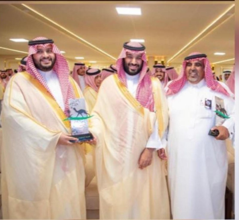 الأمير تركي بن محمد والمشرف على هجنه ابن قرينيس أثناء استلام جائزة الفوز في موسم مهرجان ولي العهد في نسخته الماضية.