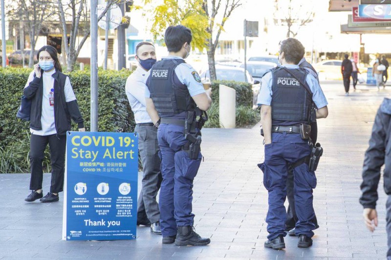 أفراد الشرطة الأسترالية يراقبون الإغلاق في سيدني.