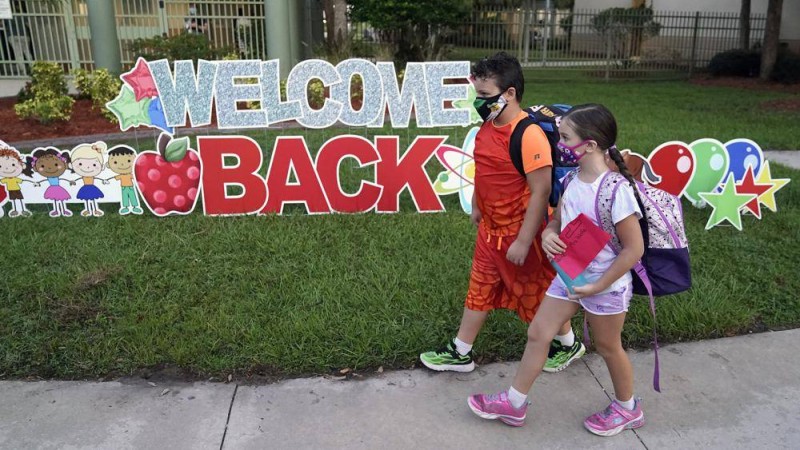 



طفلان يرتديان قناع الوجه في الطريق إلى مدرستهما بولاية فلوريدا. (وكالات)