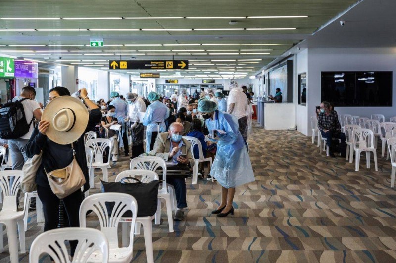 كوادر صحية يفحصون شهادات تطعيم سياح في مطار فوكيت بتايلند أمس. (وكالات)