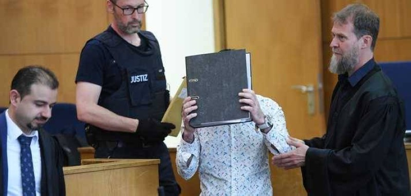 الجميلي يخفي وجهه أثناء جلسات المحاكمة.
