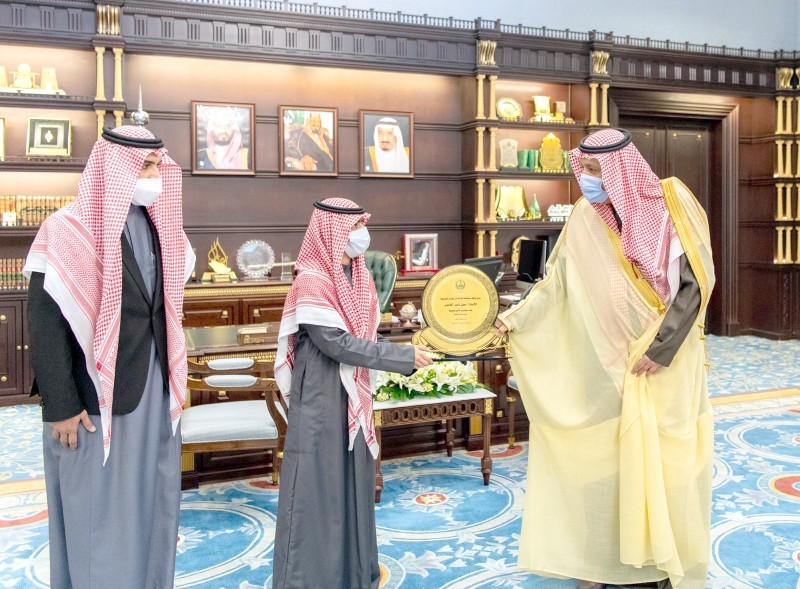 



الأمير حسام بن سعود مكرماً الغامدي. (عكاظ)
