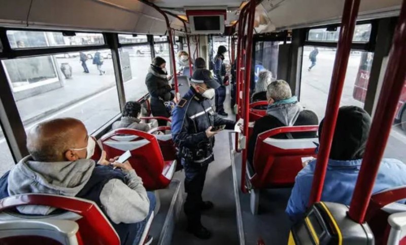 شرطي إيطالي يتفقد «التصريح الأخضر» لركاب حافلة في روما. (وكالات)