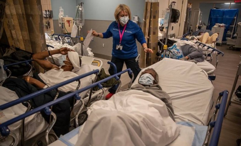 ممرضة في نيويورك تحاول العناية باثنين من مرضاها. (وكالات)