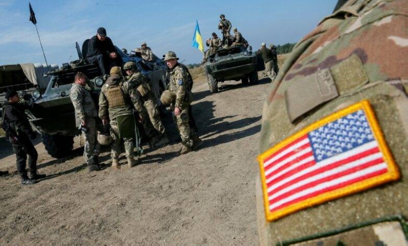 A military instructor of the U.S. Army is seen near Ukrainian servicemen during multinational drills 