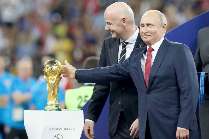 الرئيس الروسي فلاديمير بوتين يلمس كأس العالم وإلى جانبه جياني إنفانتينو رئيس الفيفا خلال نهائي مونديال 2018.