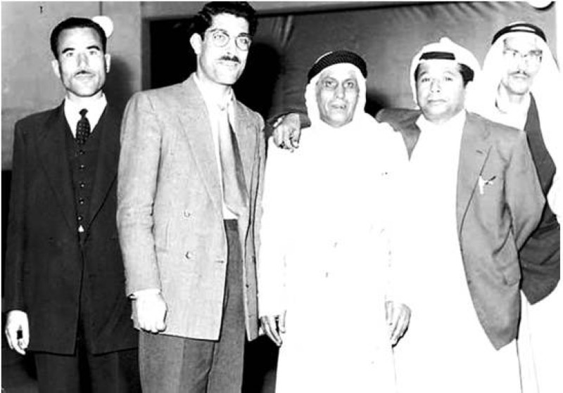 الراشد يقف خلف صديقه أحمد الزنجباري ومعهما أحمد البشر الرومي واثنين من موظفي الإذاعة الكويتية العرب.