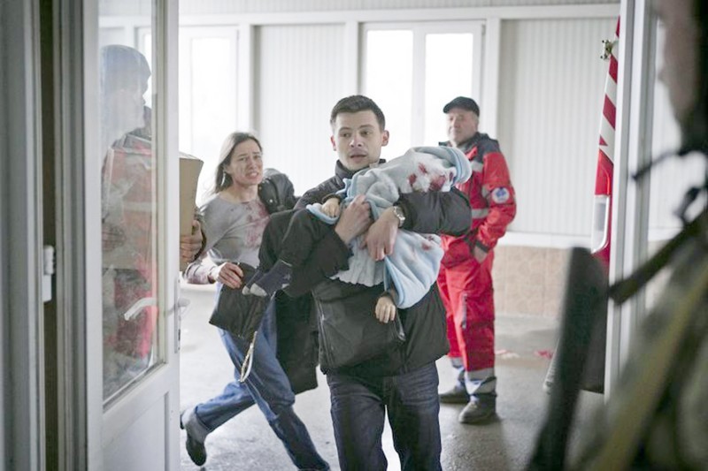



أوكراني مهرولاً يحمل طفله المصاب لإسعافه.