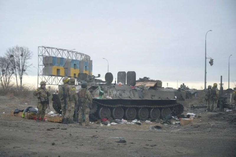 جنود أوكرانيون بجانب عربة مصفحة مدمرة على مشارف خاركيف