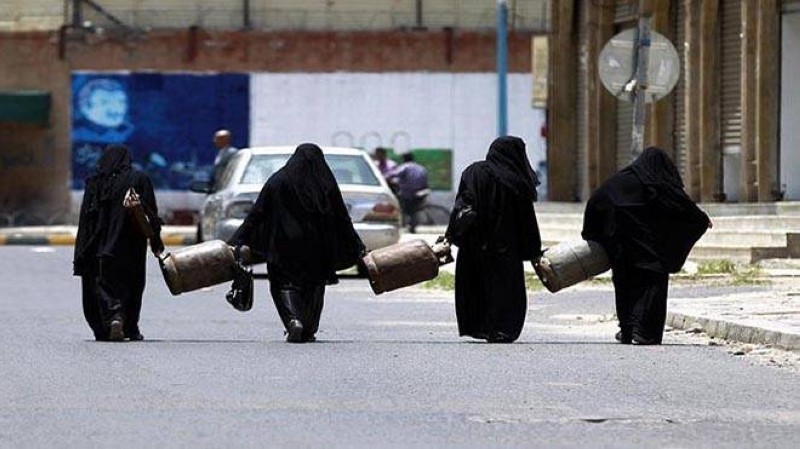 يمنيات يحملن أسطوانات الغاز في صنعاء.