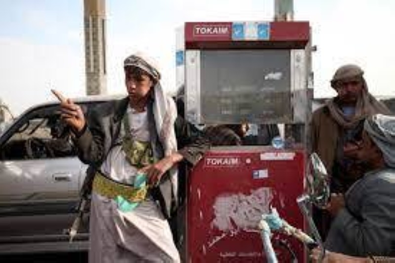 مسلح حوثي يقف على محطات البنزين لفرض الأسعار.
