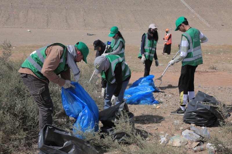 المتطوعون يقومون بإزالة النفايات من على جانبي الطريق السريع.