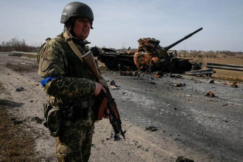 جندي أوكراني بالقرب من حطام دبابة روسية على خط المواجهة بمنطقة كييف