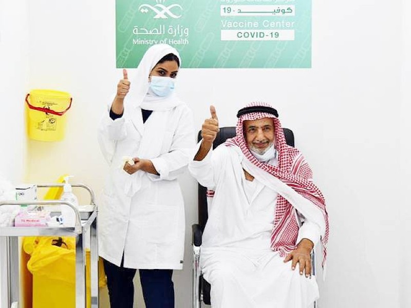     مسن وممرضة بعد أخذ الجرعة الأولى من لقاح كورونا في جدة. 