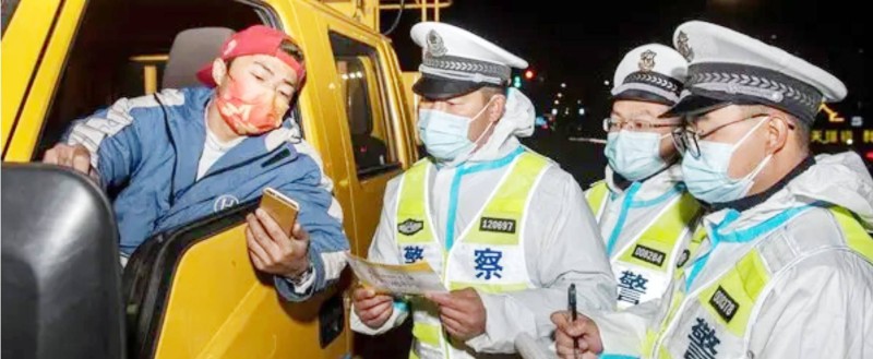 



رجال أمن صينيون يتفقدون شهادة التطعيم الخاصة بسائق شاحنة. (وكالات)