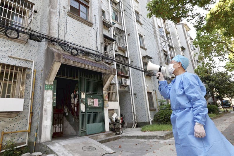 



متطوع صيني يستخدم مكبر صوت لمخاطبة سكان مبنى يخضع للإغلاق في شنغهاي. (وكالات)