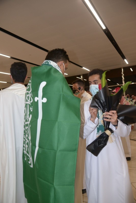 أحد الفائزين يتوشح العلم السعودي.
