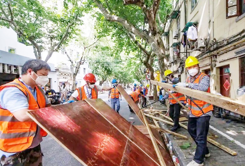 



عمال يزيلون حواجز الإغلاق أمام مجمع سكني في شنغهاي. (وكالات)
