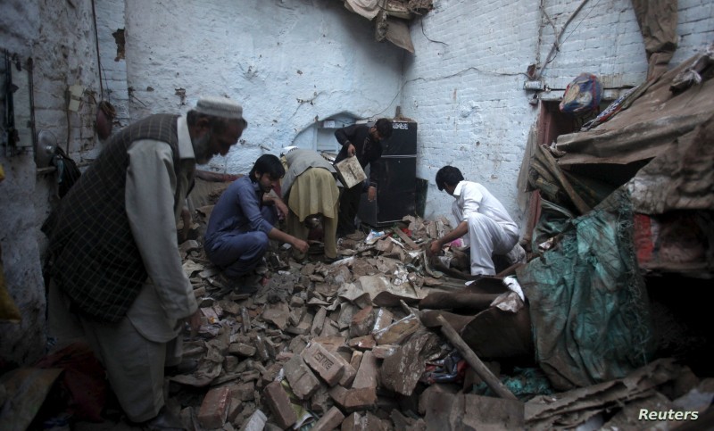 Residents search for belongings in the rubbles of a house after it was damaged by an earthquake in Peshawar, Pakistan, October 26, 2015. A major earthquake struck the remote Afghan northeast on Monday, killing at least 135 people in Afghanistan and nearby northern Pakistan and sending shock waves as far as New Delhi, officials said. REUTERS/FAYAZ AZIZ