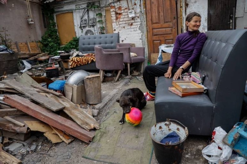 سيدة أوكرانية تجلس وسط ما تبقى من منزلها بعد عودتها إليه في ماريوبول