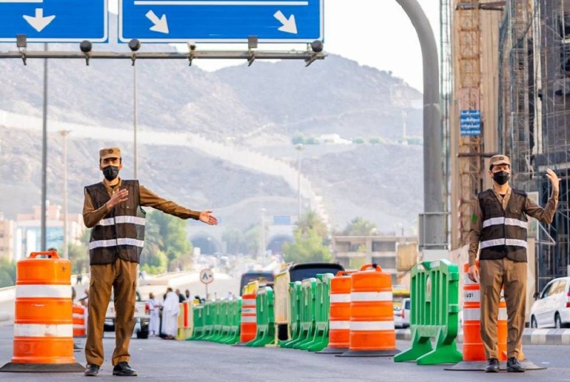 عنصرا أمن على أحد مداخل مكة المكرمة لمنع المركبات غير المرخصة من الدخول