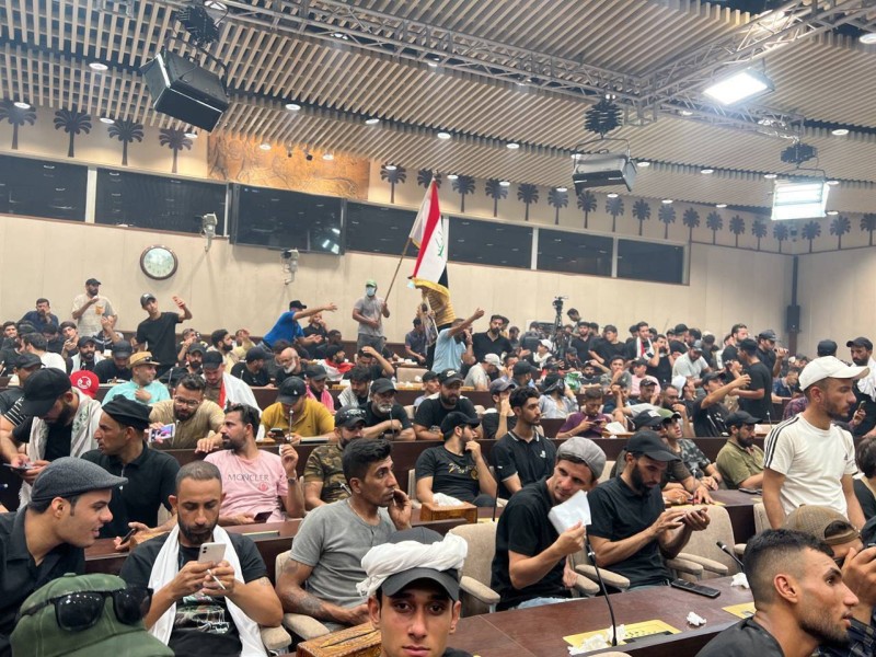 متظاهرون عراقيون على مقاعد رئيس وأعضاء البرلمان