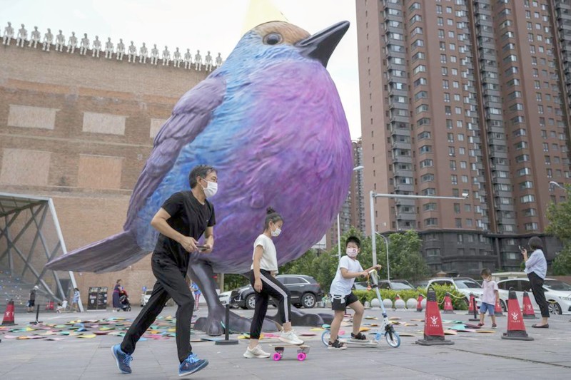 



صيني يرتدي كمامة قرب مجسم ضخم لطائر في بكين. (وكالات)
