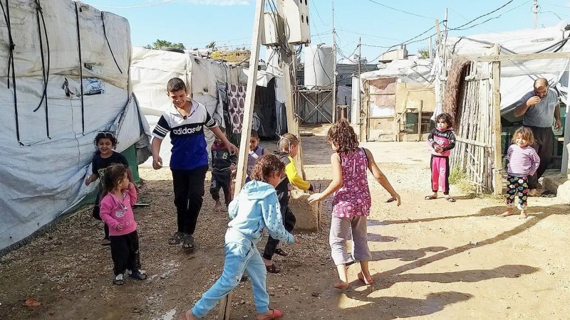 



أطفال نازحون سوريون يلهون في مخيمهم بلبنان.