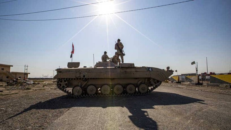 Iraqi soldiers stand atop an infantry-fighting vehicle (IFV) near a demonstration outside the southern port of Umm Qasr on November 5, 2019, after security forces attempted to break up crowds blocking the road to the port. (Photo by Hussein FALEH / AFP)