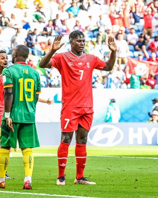 السويسري بريل إمبولو يرفع يديه بعد تسجيله هدفا ضد منتخب بلاده الأم الكاميرون.