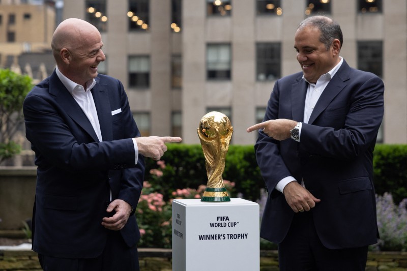 جياني إنفانتينو وفيكتور مونتالياني يقفان مع كأس العالم خلال حدث في نيويورك بعد إعلان متعلق باستضافة كأس العالم 2026. 