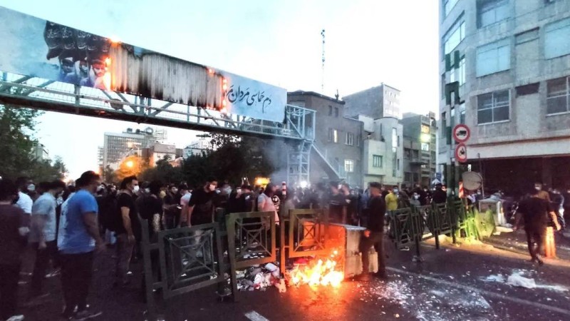  متظاهرون يحرقون إطارات السيارات.
