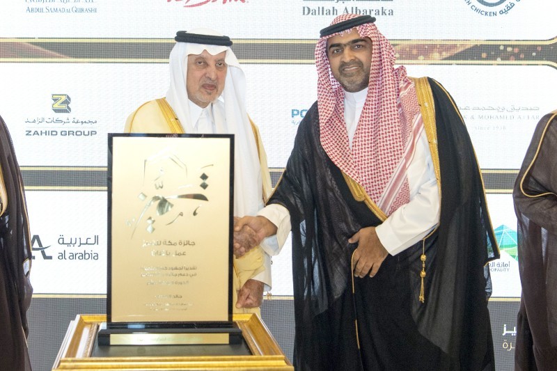 



الأمير خالد الفيصل مكرماً محيي الدين صالح كامل. (موقع الإمارة)