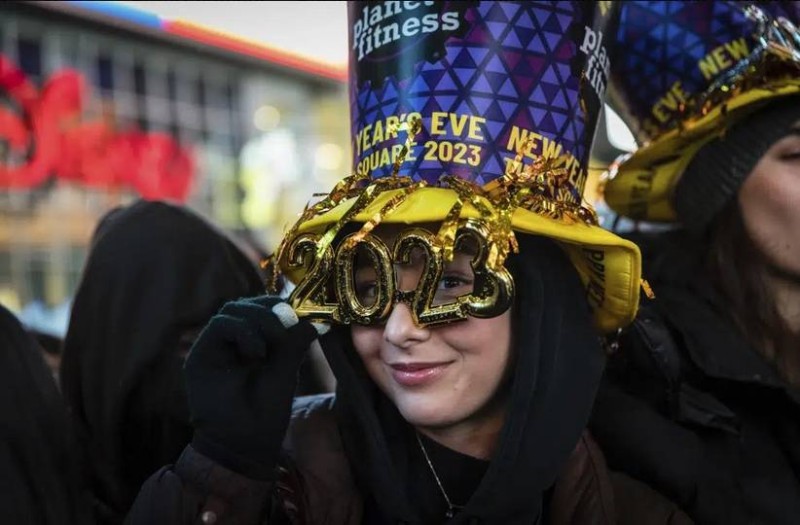 امرأة ترتدي قبعة ونظارة 2023 في تايمز سكوير بنيويورك ليلة رأس السنة. (وكالات) 