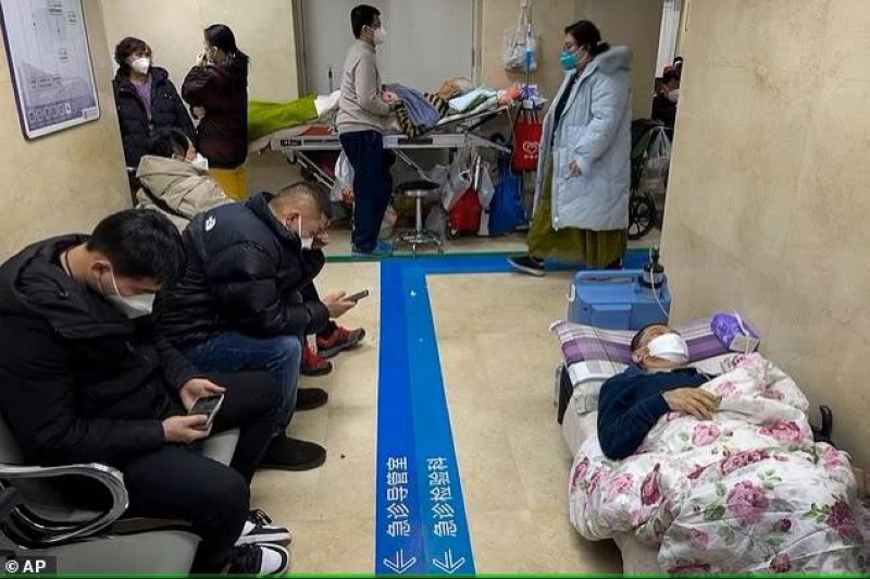 أقارب مرضى ينتظرون في مستشفى ببكين ويبدو مريض ينام على بلاط ممر المستشفى. (وكالات) 