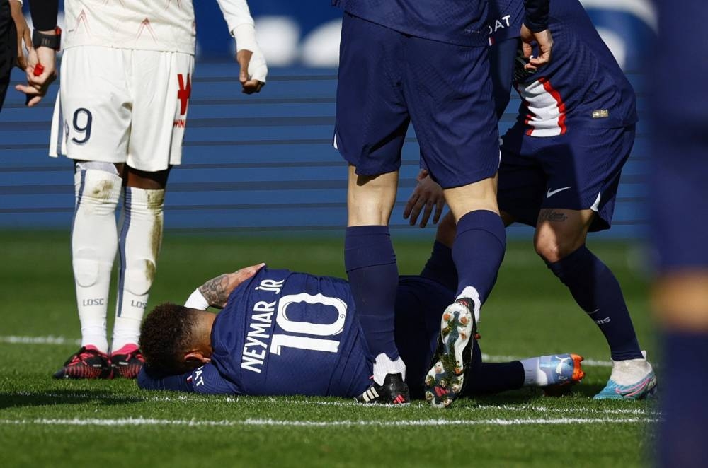 نيمار يستلقي على أرض الملعب بسبب الإصابة بعد احتكاك مع لاعب خط وسط ليل الفرنسي بنجامين أندريه.