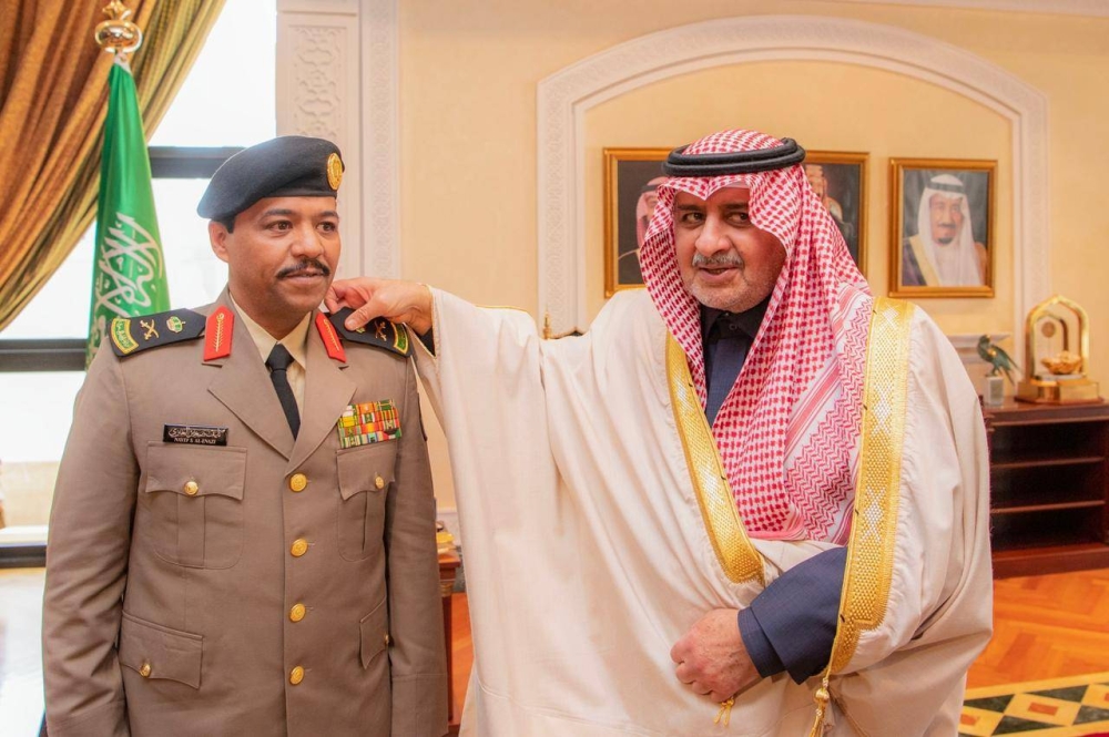 الأمير فهد بن سلطان مقلدا اللواء العنزي رتبته الجديدة. (عكاظ) 