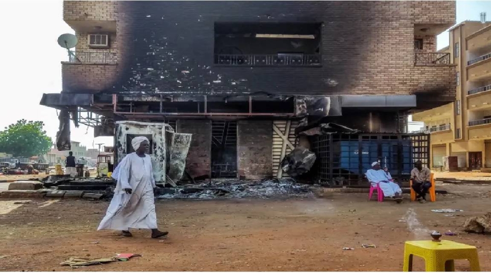 سوداني يمر بجوار منزل محترق في العاصمة الخرطوم.