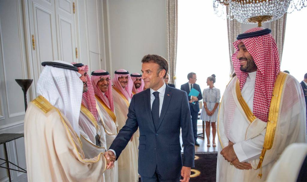 الرئيس الفرنسي مصافحا الوفد المرافق لولي العهد