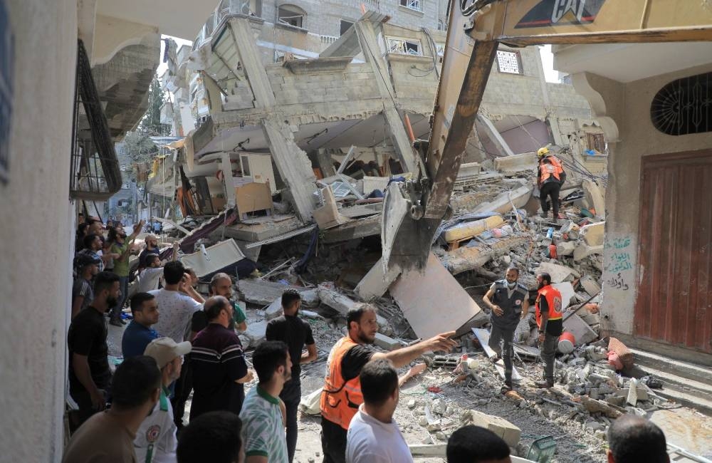رجال الإنقاذ يخرجون جثث الضحايا من تحت أنقاض منازل دمرتها إسرائيل.